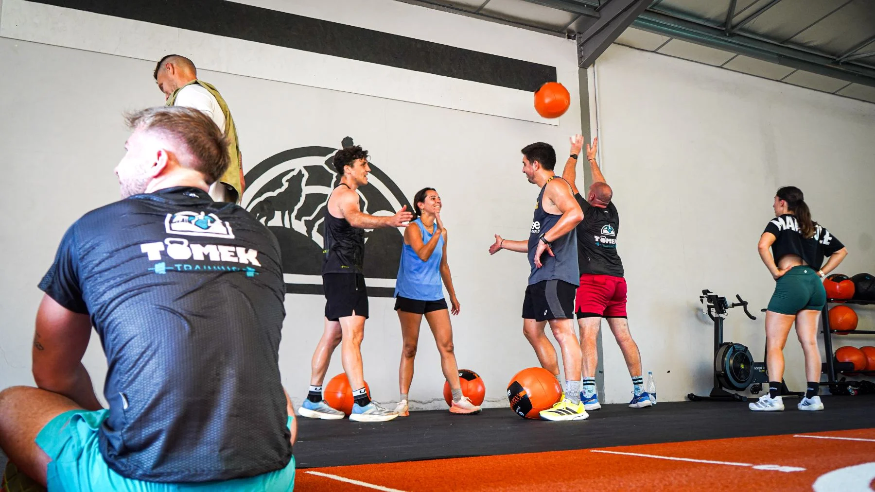 Le coach et les adhérents de Tomek Training rient pendant une séance de wall balls dans la salle de Pouyastruc