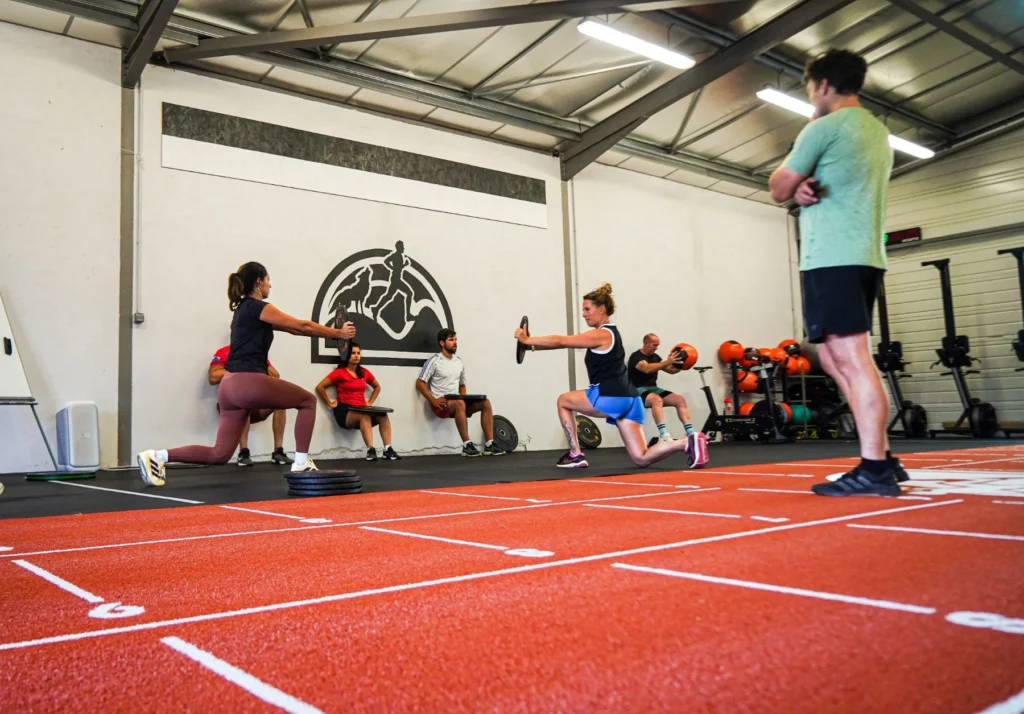 Cours de renforcement musculaire : fentes avec disques en groupe